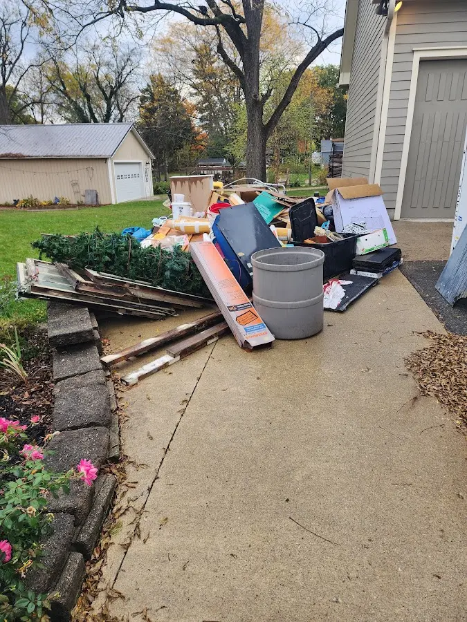 Dumpster being loaded with debris for 12 Yard Dumpster Rental in Crown Point